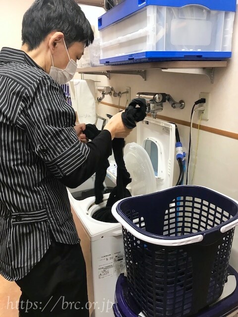 脱水機から洗ったタオルを取り出すA様